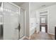 Bright bathroom showing a shower, tub, and an open doorway to the main bedroom with hardwood floors at 3546 Bridge Walk Dr, Lawrenceville, GA 30044