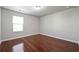 Bright bedroom with hardwood floors illuminated by a large window at 3546 Bridge Walk Dr, Lawrenceville, GA 30044
