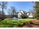 Spacious backyard showcasing a pristine pool, manicured lawn, and the elegant exterior of the modern home at 4555 Mystic Dr, Atlanta, GA 30342