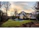 Expansive backyard at sunset featuring a modern pool and lush green lawn with a large, elegant home at 4555 Mystic Dr, Atlanta, GA 30342