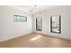 Spacious bedroom with light hardwood floors, modern light fixture, and black frame windows overlooking nature at 4555 Mystic Dr, Atlanta, GA 30342