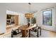 Elegant dining room with a modern light fixture, a wooden table, and large windows offering backyard views at 4555 Mystic Dr, Atlanta, GA 30342