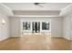Bright living room with hardwood floors, modern light fixtures, and black frame windows overlooking nature at 4555 Mystic Dr, Atlanta, GA 30342