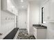 Mudroom with gray-and-white herringbone-style tile floor, hooks, seating, cabinets, and utility sink at 4555 Mystic Dr, Atlanta, GA 30342
