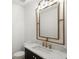 Modern powder room featuring white marble countertop, a dark vanity, and a gold-framed mirror at 4555 Mystic Dr, Atlanta, GA 30342
