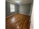 Cozy bedroom showcases hardwood floors, neutral walls and a bright window for natural lighting at 4762 Old Highgate Entry, Stone Mountain, GA 30083
