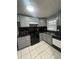 Well-lit kitchen boasts ample gray cabinets, modern black appliances, and sleek black countertops at 4762 Old Highgate Entry, Stone Mountain, GA 30083