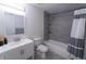 Modern bathroom featuring shower over bath, sleek gray tile, large mirror, and a contemporary white sink at 446 Mcgill Ne, Atlanta, GA 30312