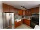 Well-lit kitchen features stainless steel refrigerator, stone countertops, mosaic backsplash, and wooden cabinetry at 446 Mcgill Ne, Atlanta, GA 30312