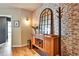Charming foyer with brick wall, wood floors, mirrored accent piece, and a coat rack at 923 Peachtree Ne St # 1628, Atlanta, GA 30309