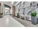 Modern lobby with tile floors, patterned wall, bench, plants, and view of the entrance at 923 Peachtree Ne St # 1628, Atlanta, GA 30309