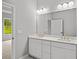 Bright bathroom features a double sink vanity with gold fixtures and a large mirror at 1101 Cooks Farm Way, Woodstock, GA 30189