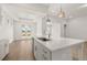 Bright kitchen featuring a large island with white countertops, modern pendant lighting, and hardwood floors at 1649 Tielman Way, Snellville, GA 30078