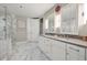 Modern bathroom featuring double vanity sinks, a glass shower, and marble tile floors and walls at 270 17Th Nw St # 2804, Atlanta, GA 30363
