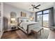 Modern bedroom with large window, ceiling fan, hardwood floors, and neutral color scheme at 270 17Th Nw St # 2804, Atlanta, GA 30363