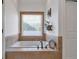 Bathroom with a soaking tub, tiled surround, and a large window at 525 Waters Way, Fayetteville, GA 30215