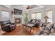 Cozy living room featuring hardwood floors, a fireplace, large windows, and comfortable seating for relaxing and entertaining at 525 Waters Way, Fayetteville, GA 30215