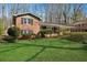 Charming brick home featuring a lush green lawn and a covered front porch, nestled among mature trees at 731 Fern Se St, Marietta, GA 30067