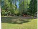 View of the backyard with lush lawn, surrounded by mature trees and a storage shed at 4038 Se Clay Court Se Se, Conyers, GA 30013