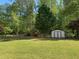 Lush backyard featuring a storage shed, sitting area, and well-maintained lawn at 4038 Se Clay Court Se Se, Conyers, GA 30013