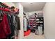 Walk-in closet with clothes hanging on a rod and shelves filled with shoes and folded clothing at 5884 Grande River Rd, Atlanta, GA 30349
