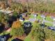 An aerial view showcases a charming neighborhood with homes nestled among colorful trees and well-manicured lawns at 12 Windcrest, Covington, GA 30016