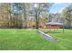 A spacious backyard features a large grassy lawn, mature trees, a wooden platform, and a gazebo, offering plenty of outdoor space at 12 Windcrest, Covington, GA 30016