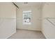 Walk-in closet with built-in shelving and a window overlooking the front yard at 12 Windcrest, Covington, GA 30016