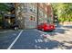 Stone building with balconies and a red car parked in parking space at 198 Ponce De Leon Ne Ave # 5D, Atlanta, GA 30308