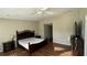 Large main bedroom with hardwood floors, dual nightstands, and access to private bathroom at 2820 Skye Ter, Duluth, GA 30096