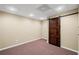 Finished basement with a dark wooden sliding door and neutral colored walls at 330 Meadowcrest Cir, Canton, GA 30115