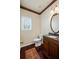Well-lit bathroom with a decorative mirror, dark wood cabinets, and a granite countertop at 330 Meadowcrest Cir, Canton, GA 30115