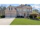 Charming brick two-story home with a well-manicured lawn and a two-car garage at 330 Meadowcrest Cir, Canton, GA 30115