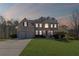 Charming brick two-story home with a well-manicured lawn and a two-car garage at dusk at 330 Meadowcrest Cir, Canton, GA 30115