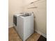 Modern laundry room featuring stainless steel appliances, neutral walls, and tile floor at 330 Meadowcrest Cir, Canton, GA 30115