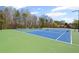 Beautiful community tennis courts with green and blue surfaces surrounded by mature trees at 330 Meadowcrest Cir, Canton, GA 30115