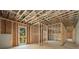 Unfinished basement with wooden framing, concrete floors, and a glass door leading to the outside at 6055 Tattnall Overlook, Acworth, GA 30101