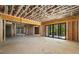 Unfinished basement featuring exposed wooden beams, concrete flooring, and a large sliding glass door at 6055 Tattnall Overlook, Acworth, GA 30101