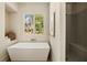 Bright bathroom showcasing modern tub next to window and gray tiled shower with built in seat at 6055 Tattnall Overlook, Acworth, GA 30101