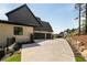 Long driveway leading to a three-car garage on a brick home with black trim and landscaping at 6055 Tattnall Overlook, Acworth, GA 30101