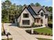 An exterior view of a two-story home with black trim, brick accents and a three car garage at 6055 Tattnall Overlook, Acworth, GA 30101