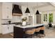 Modern kitchen with white cabinets, a black island, pendant lights, and bar stools at 6055 Tattnall Overlook, Acworth, GA 30101
