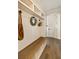 Inviting mudroom with bench, decorative hooks, storage cubbies and light hardwood floors at 6055 Tattnall Overlook, Acworth, GA 30101