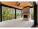 Covered patio with stained wood ceiling, brick fireplace, and black railing overlooking wooded backyard at 6055 Tattnall Overlook, Acworth, GA 30101