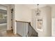 Bright staircase with oak steps, white risers, and black iron railings, illuminated by a modern chandelier at 6055 Tattnall Overlook, Acworth, GA 30101