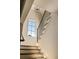 Elegant staircase with oak steps, white risers, and black iron railings, illuminated by a modern chandelier at 6055 Tattnall Overlook, Acworth, GA 30101
