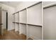 Spacious walk-in closet with custom shelving and hanging racks, and light hardwood floors at 6055 Tattnall Overlook, Acworth, GA 30101