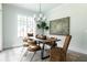 Dining room features a wood table with unique chairs, modern chandelier, and large windows at 64 Telfair Ct, Acworth, GA 30101