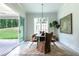 Dining room features a wood table with unique chairs, modern chandelier, and large windows at 64 Telfair Ct, Acworth, GA 30101
