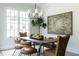 Dining room features a wood table with unique chairs, modern chandelier, and large windows at 64 Telfair Ct, Acworth, GA 30101